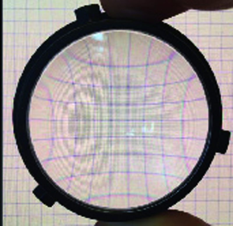 実際のVR-HMDに採用されている接眼レンズを通して方眼紙を見たときの情景。糸巻き状に外周が凹んで歪んでいるのがわかる。