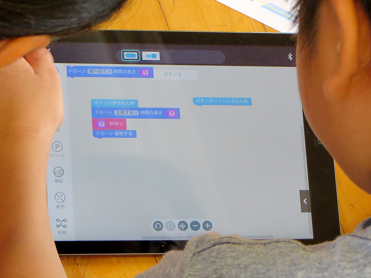 ボタンのコードを開くと、Scratchと同じブロックプログラミングの画面が表示され、ドローンを動かす命令を定義することができる