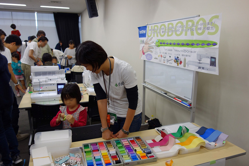ブラザー工業株式会社は、電気を通す糸とミシンを使って目が光るブレスレット「UROBOROS」を披露。女の子に人気だった