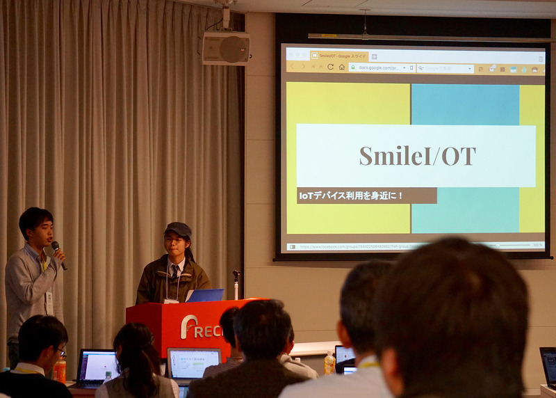高校生チーム（山田陽大さん、足立素音さん、田島融樹さん、出川大和さん）が開発した「SmileI/OT」は、プログラミング不要でIoTデバイスをカスタマイズできるシステム。Raspberry Piの上でWebサービスを動かし、さまざまなセンサの入力をTweetで行う設定ができる
