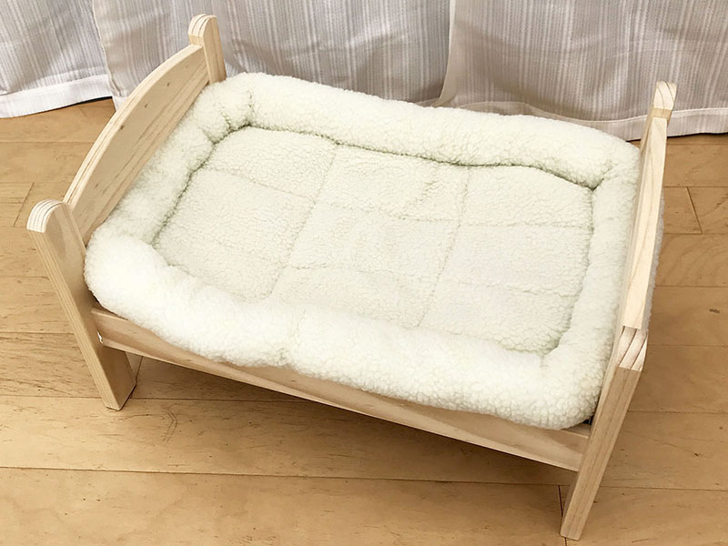 これがIKEAの「人形用ベッド」。上にペット用マット（別売品）を敷いています。「猫用ベッド」の異名があるほど、猫にピッタリのサイズなんです。イケアストア価格は2499円（税込）