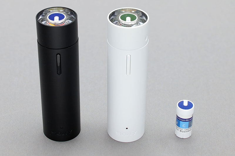 ソニーの「AROMASTIC（アロマスティック）」。本体（パーソナルアロマディフューザー）は約直径2.5cm×長さ8.5cmの筒状で、ボタンを押すと瞬時に好みの香りを射出。鼻の近くで使い、自分だけで香りを楽しめます。USB充電式（microUSB/約2時間で満充電）で、1日10回の使用で約1カ月使用可能。本体カラーはブラックとホワイトがあり、本体のメーカー価格は3,980円（税別）。右に見える小さな円柱は、香り（精油）を収めた「パーソナルアロマカートリッジ」です