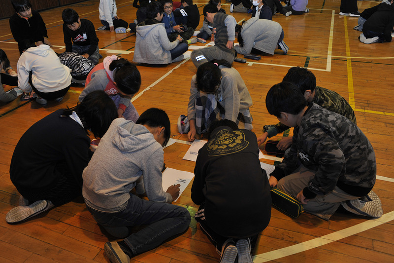 配布資料に決まったことを書き入れていく児童たち