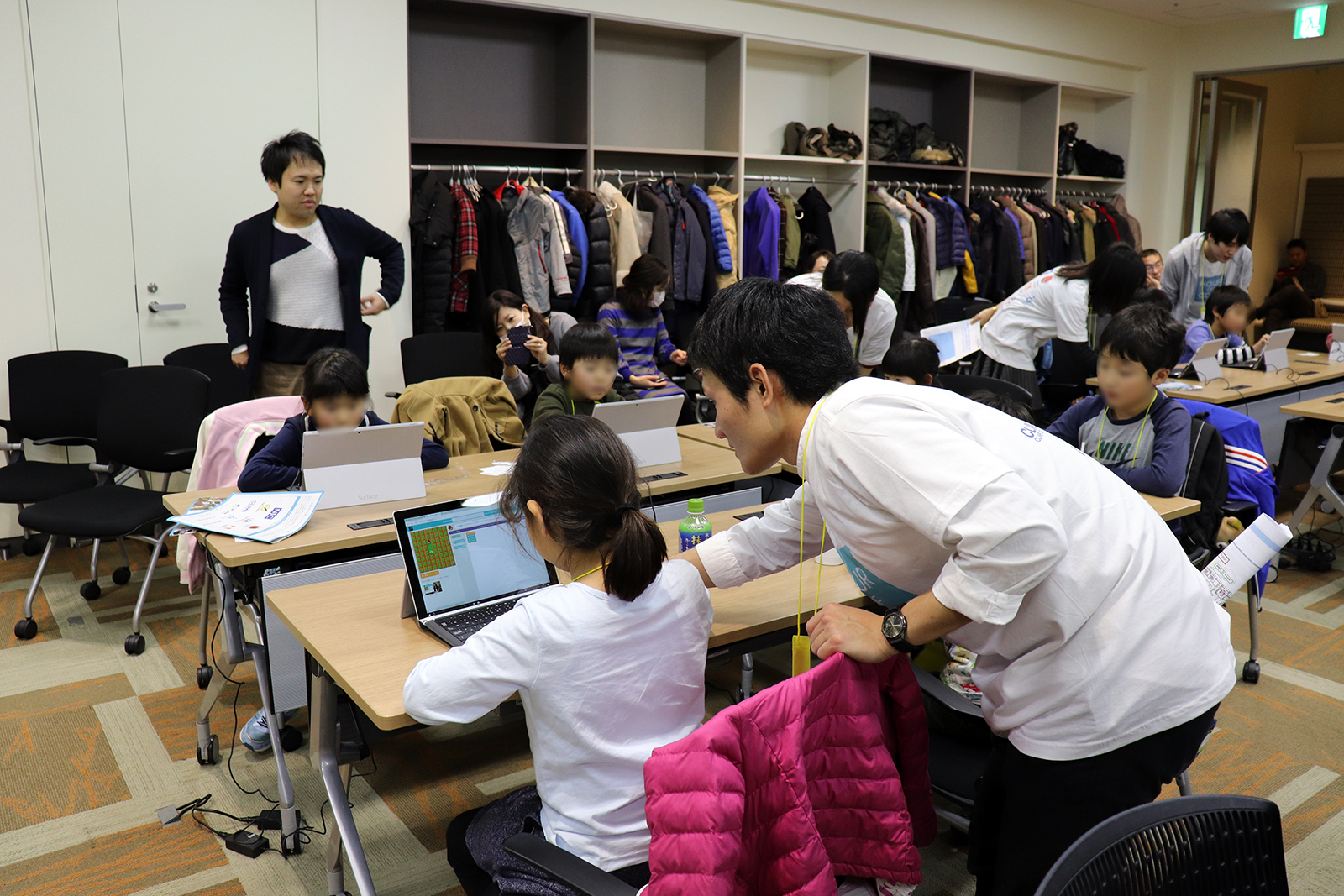 ワープショップには、みんなのコードの多数のボランティアが参加。プログラミングに行き詰った子どもに積極的に声をかけてアドバイスする姿や、上手くできている子どもに対しては「すごいねー」、「がんばってやったねー」と褒める姿がいたるところで見受けられた