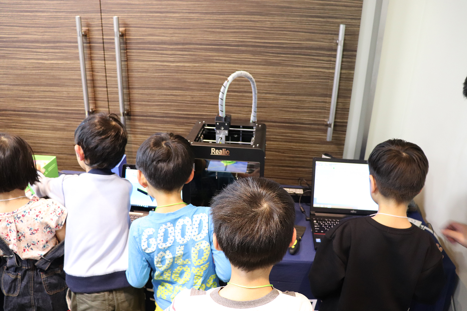 3Dプリンタに興味津々な子どもたち。何もないところから徐々に造形されるものに、子どもも大人も関係なくつい見入ってしまう