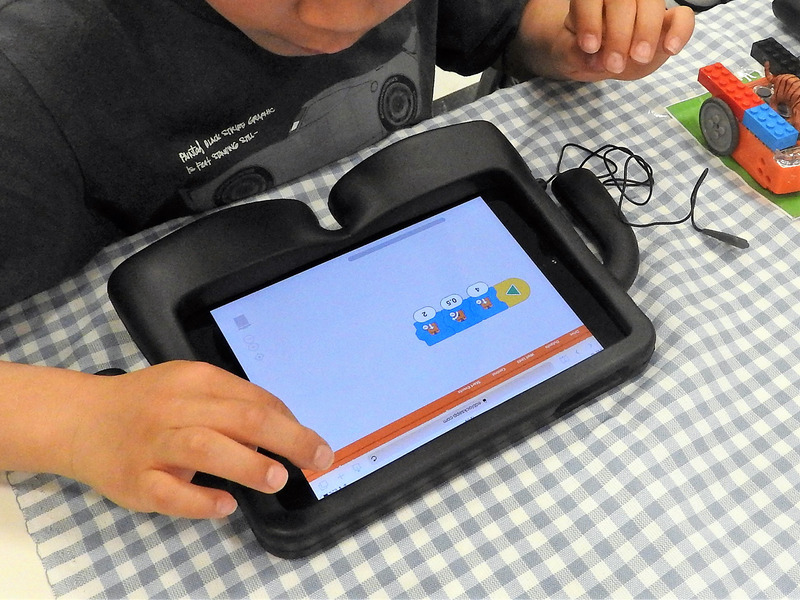 タブレットやPCでブロックを並べてプログラミングが可能。ロボットへのプログラムの転送はヘッドホン端子経由で行う