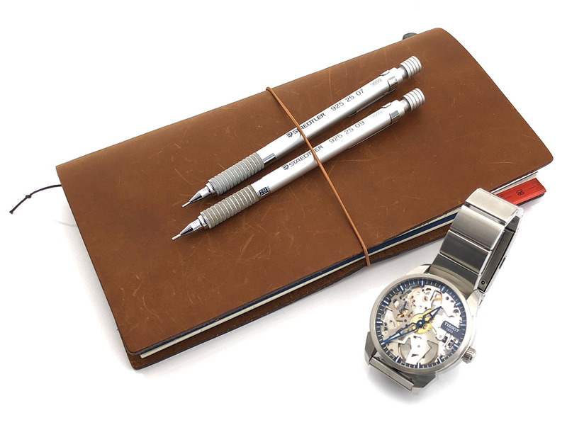 筆者が使用中の「自由に書ける手帳」と「カッコイイ機械式腕時計」と「書き心地の良い筆記具」。自分のなかに出現しちゃうネガティブな気持ち、意外なほど「どうにかしてくれる」という頼もしい存在です