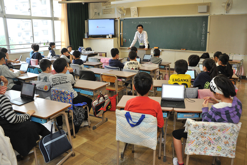 2人1組で1台のタブレットPCを利用する児童たち