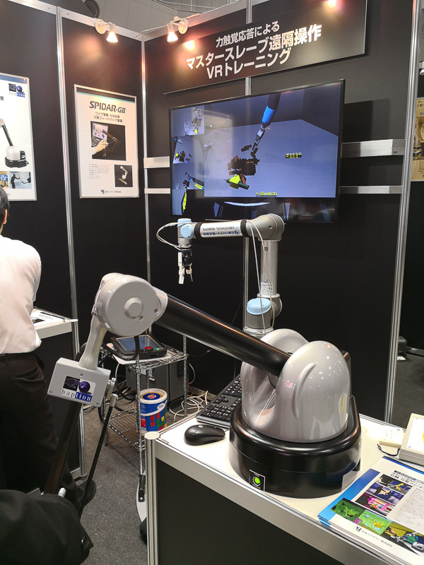 日本バイナリーのブースで体験できる「6軸力覚フィードバック装置」（左）と、ワイヤー式の6軸ハプティックデバイス「SPIDAR-GII」