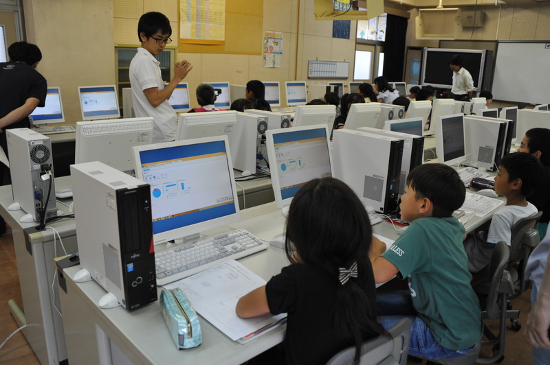 回答結果のグラフとそれを見て感心する児童達