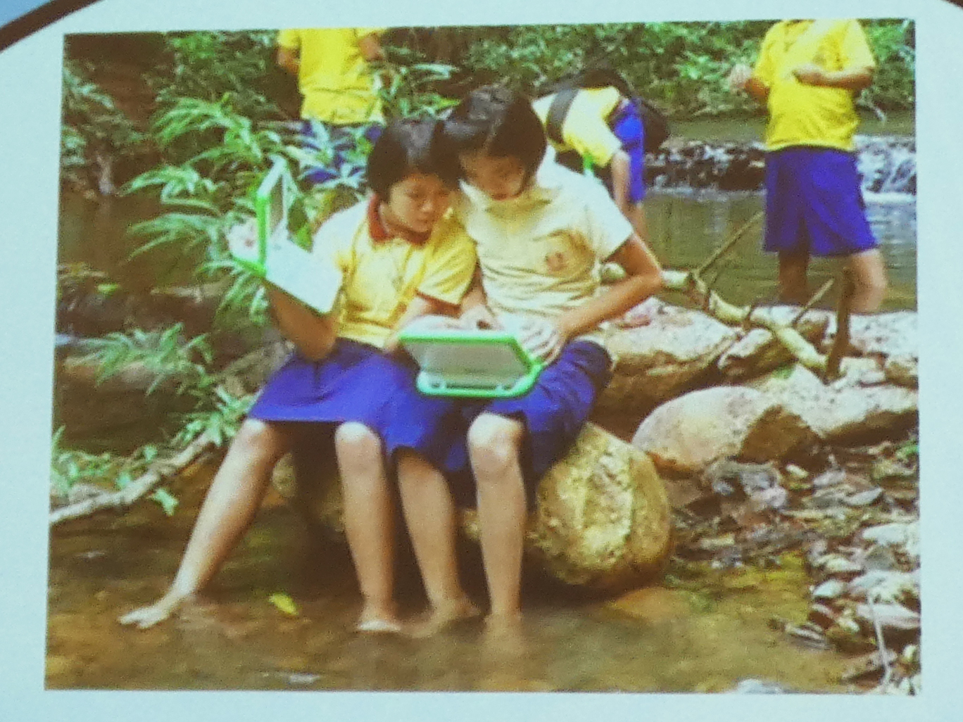 PCを野外で使用するタイの子どもたち