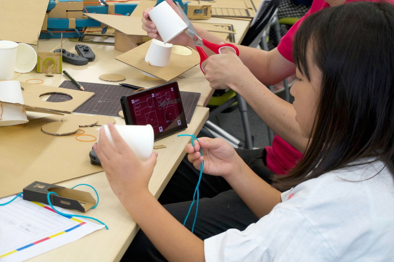 Switch画面でのプログラミングと工作を平行してどんどん手を動かしていく子ども達