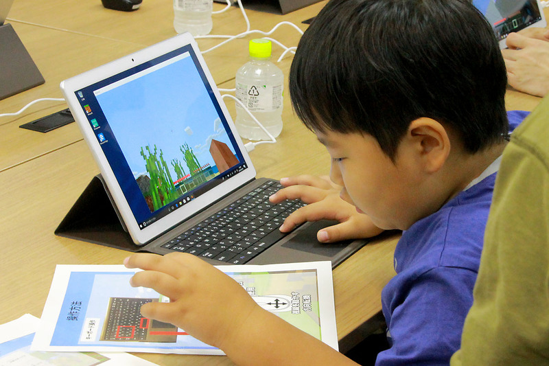 初めてパソコンでのマインクラフトに、説明書を見ながら操作をする子ども達