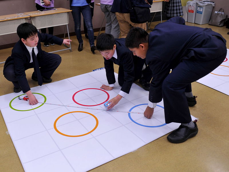 コースを計測し、コーディングブロックでプログラミングの内容を検討する児童達