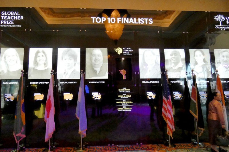 最終日の24日、トップ10にノミネートされた教師の写真と国旗が並ぶ