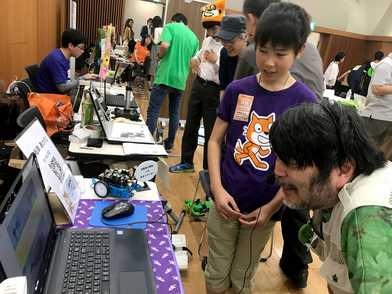 Scratch猛者たちが居並ぶ準備中の展示コーナーと、小学生の作品「自転車　あっ！」を体験する筆者