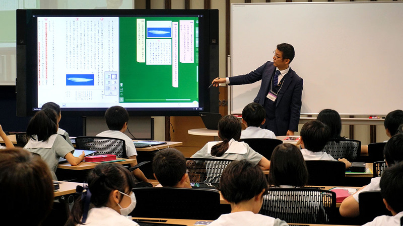 授業はデジタル教科書の投影とホワイトボードの板書の両方で進められる