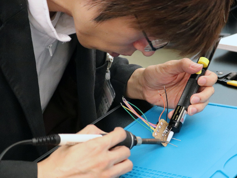ハンダづけの不良を、ハンダ吸取り器でハンダを取り除き、再度きれいにハンダ付けし直す村上氏
