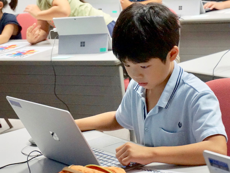 熱心にプログラミングに取り組む子どもたち、パソコンは初めての子もすぐに操作に慣れて課題を進めていく