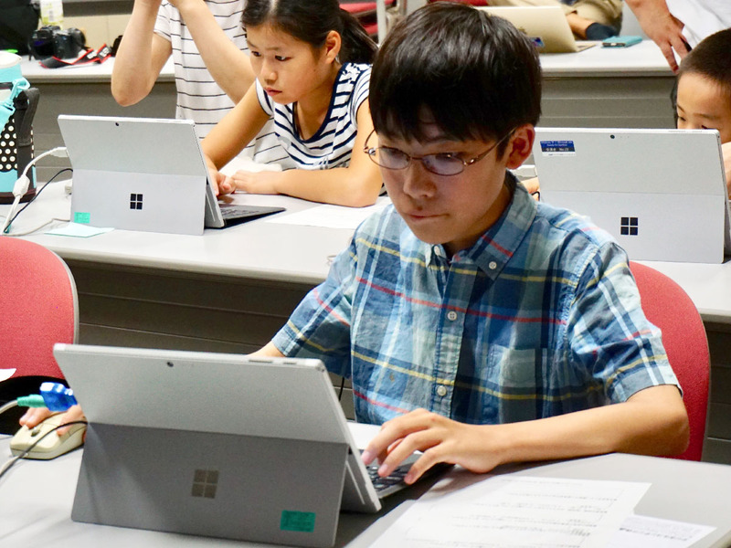 熱心にプログラミングに取り組む子どもたち、パソコンは初めての子もすぐに操作に慣れて課題を進めていく
