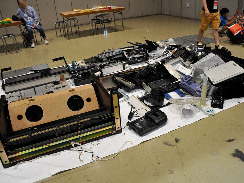 なかなか壮絶な機械の山に、お持ち帰り自由の分解部品も並ぶ