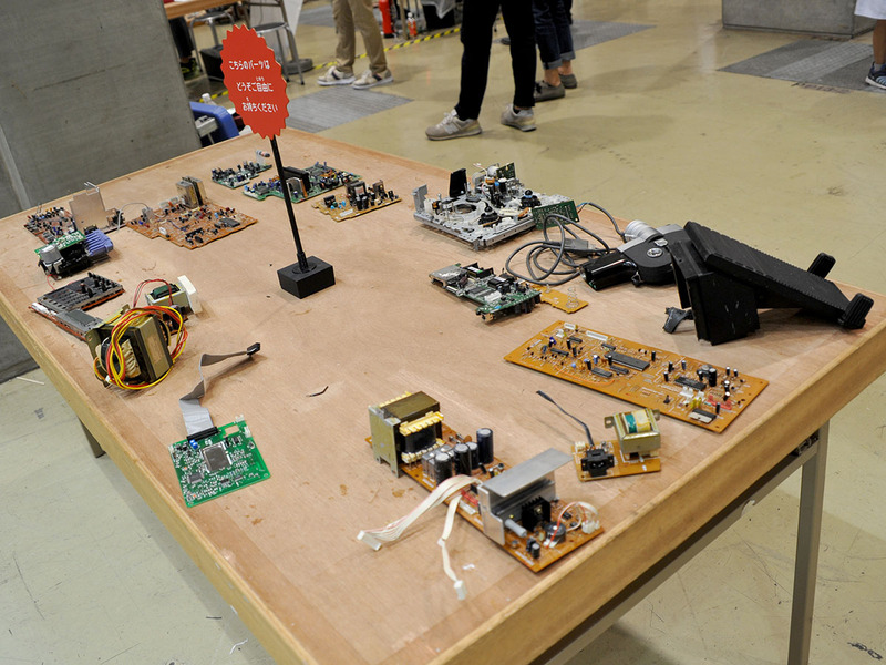 なかなか壮絶な機械の山に、お持ち帰り自由の分解部品も並ぶ