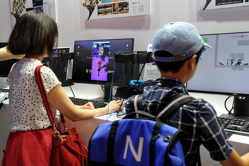 学生作のゲームで遊ぶ来場した子どもたち、なかには親子で遊ぶ姿も