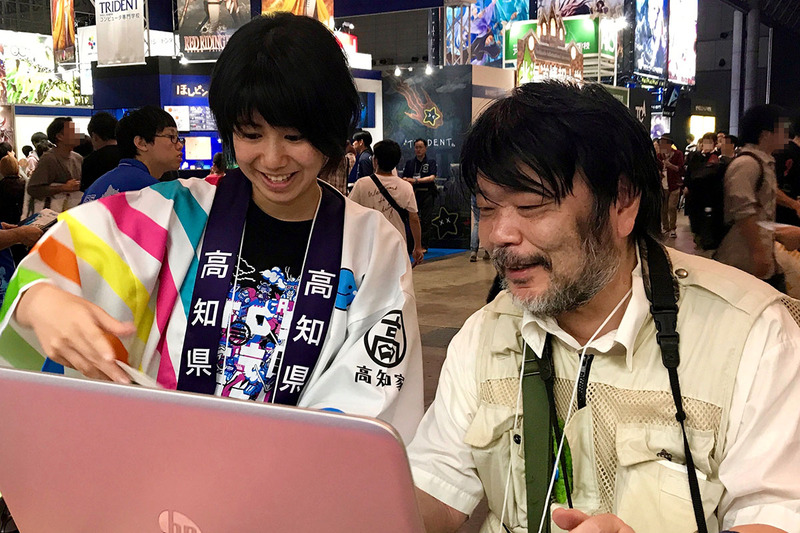 説明を受けながら学生作のゲームを試遊する筆者