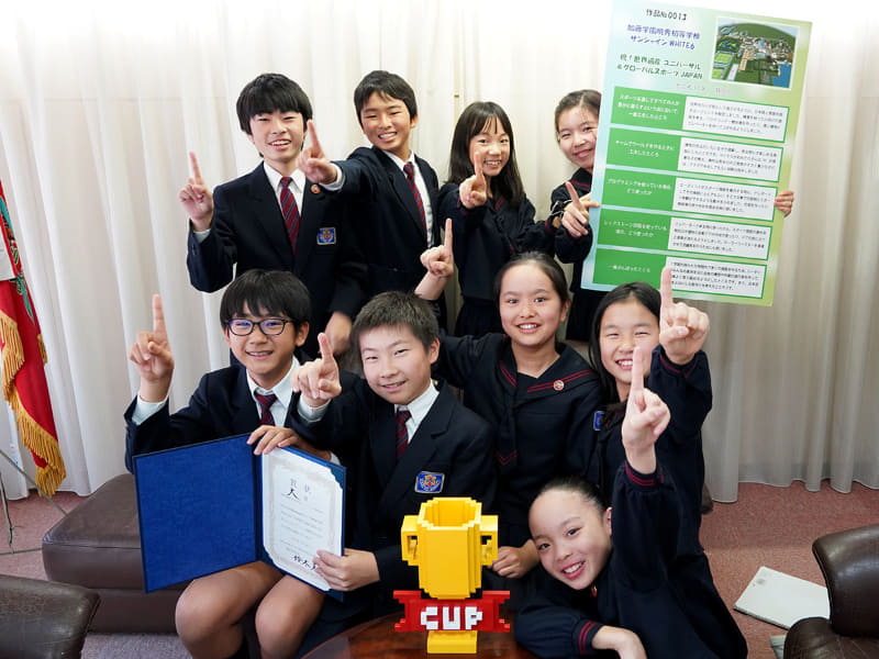 チームを代表してインタビューに協力してくれた加藤学園暁秀初等学校6年生の皆さん（後列左から工藤大治さん、吉田裕吾さん、本柳亜呼さん、森谷桃果さん、中列左から塚本竜平さん、岩﨑辰海さん、大月優佳さん、土屋心優さん、前列右は大山寧々さん）