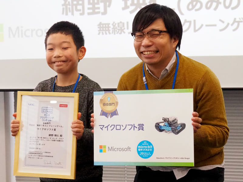 自由部門のマイクロソフト賞を受賞した網野瑛仁さんには、審査員のレノボ・ジャパン株式会社 開発オペレーションズ・事業計画管理 中村鉄平氏からMakeblockプログラミングロボット mBot Rangerが贈られた
