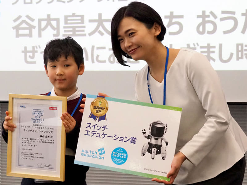 課題解決部門のスイッチエデュケーション賞を受賞した谷内皇太さんには、小室氏からプログラミング・フォロ for micro:bitが贈られた