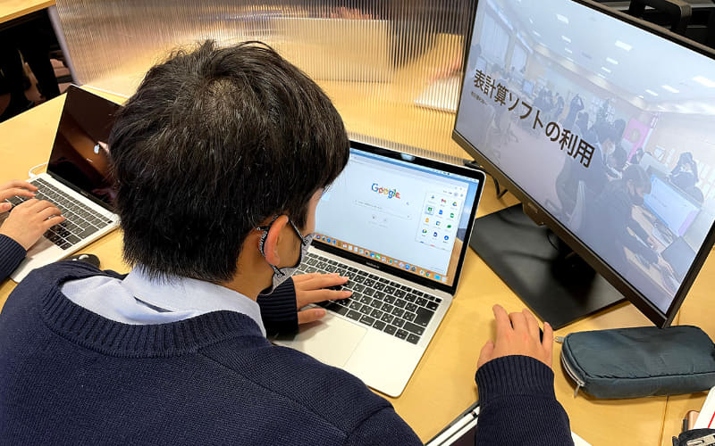 情報の授業では、生徒たちはMacbookやサブモニターを使って課題に取り組みます