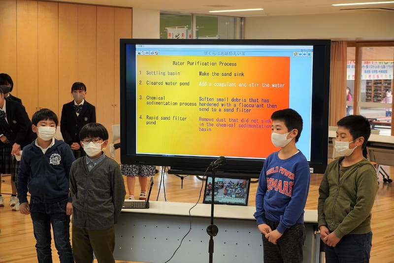 小学4年生の男子児童らによる発表。環境問題で学んだことを英語のスライドにまとめ、元気よく発表した