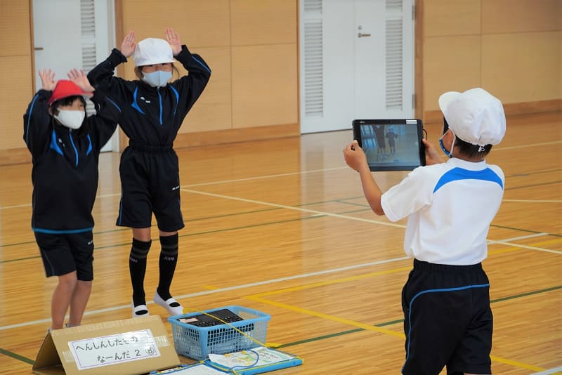 1年生の体育の授業。動作を動画で撮影し、それを見ながらグループで振り返り