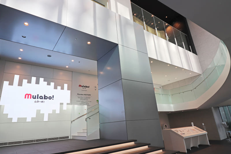 らせん階段のある吹き抜けのスペースにはオリジナル映像が流れる大型スクリーンも