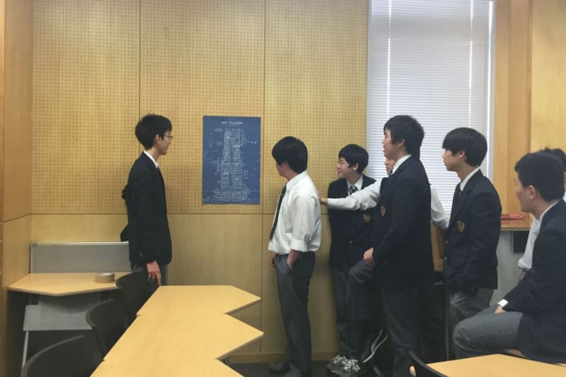 ポスターを見ながら、議論する生徒たち