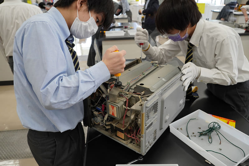 「ものづくりとSTEAM」のゼミ。木のものづくりや、ラジオ製作、レーザーカッターや３Dプリンタなど、手を動かすものづくりを体験。この日は教員が学内からかき集めた電化製品を生徒が分解し、中身をiPadで撮影して構造を理解するという内容だった