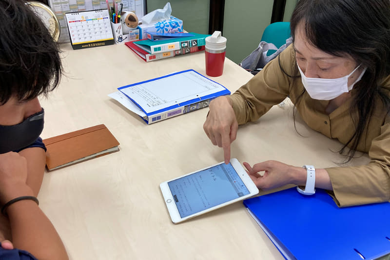 ディスレクシア（読み書き障害）を持つ子の対応をする先生に、Microsoft Lensの使い方を説明（両川氏提供）