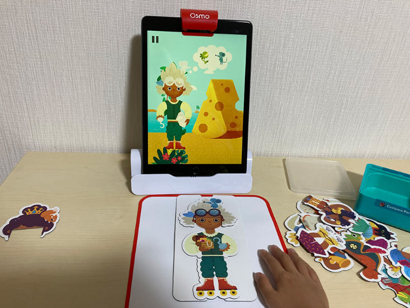 「Osmo リトル ジーニアス スターター キット」は、好きな服や髪形のパーツを使って着せ替え遊びが楽しめる「Costume Party」や、シチュエーションに合わせて必要なコスチュームを選ぶ「Stories」というゲームも用意されている