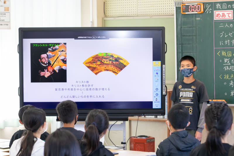 自分の意見をプレゼンテーションで主張する児童