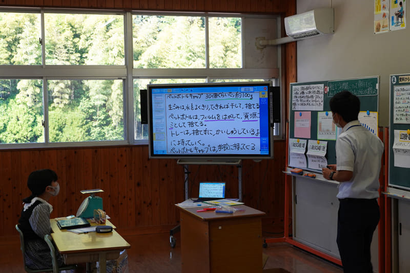 6年生の授業の様子。授業支援ソフトのワークシートに書き込み、それを電子黒板に写しながら教員と対話
