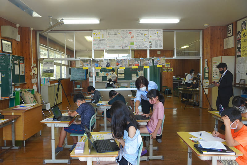 手前は5年生、奥が6年生の授業となる。橋本教諭は5・6年生のスペースを行ったり来たりしながら指導する