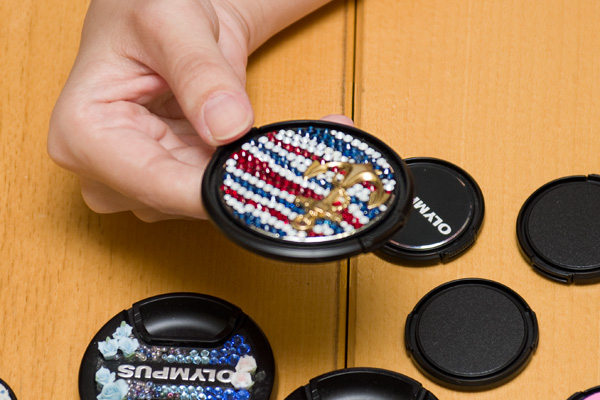 ラインストーンがびっしり配置されたキャップ。メーカーロゴを完全に隠すためにはこうしてスキマなく配置しなければいけない。写真右手にあるのがロゴなしキャップ