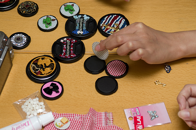 型紙にあわせて布地やシール、前述の革などを切り抜いて貼り付ける