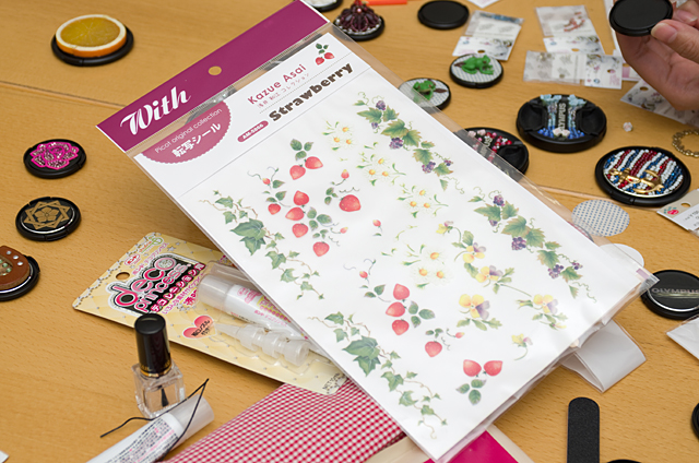 実際に取り出してくれた転写シールを貼ったレンズキャップ。シール自体はきれいなのだが、土台となるキャップ自体が黒地なので、輪郭がぼやけてしまっている。これではいくらきれいなシールを貼ったとしても、色やデザインが映えないだろう。