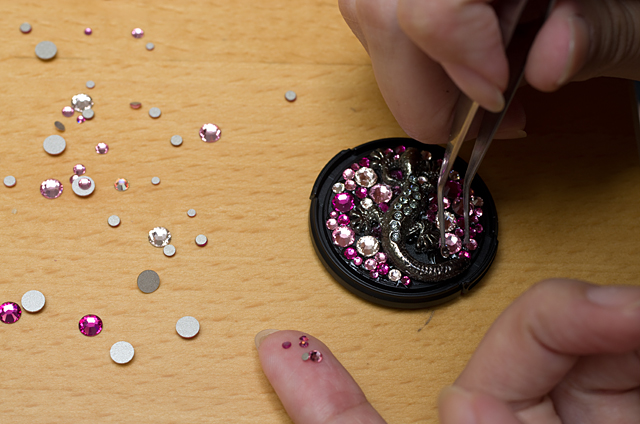 世間話をしながらもスイスイと作業を進める葵さん。トカゲのモチーフの陰にできたスキマにもストーンを埋め込んでいく「潜り込ませ」を駆使しながら、びっちりと配置していく