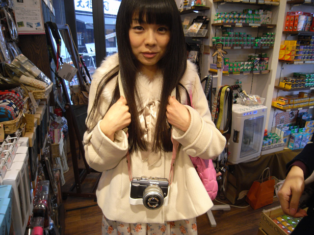 ストラップの長さは、数字だけ見るとちょっと短めかな？と思いましたが、実際につけてみるとちょうどいい感じ。白とピンクの模様が服装とカメラにもバッチリ合っています。ストラップの長さを縮めれば首掛けもOK?