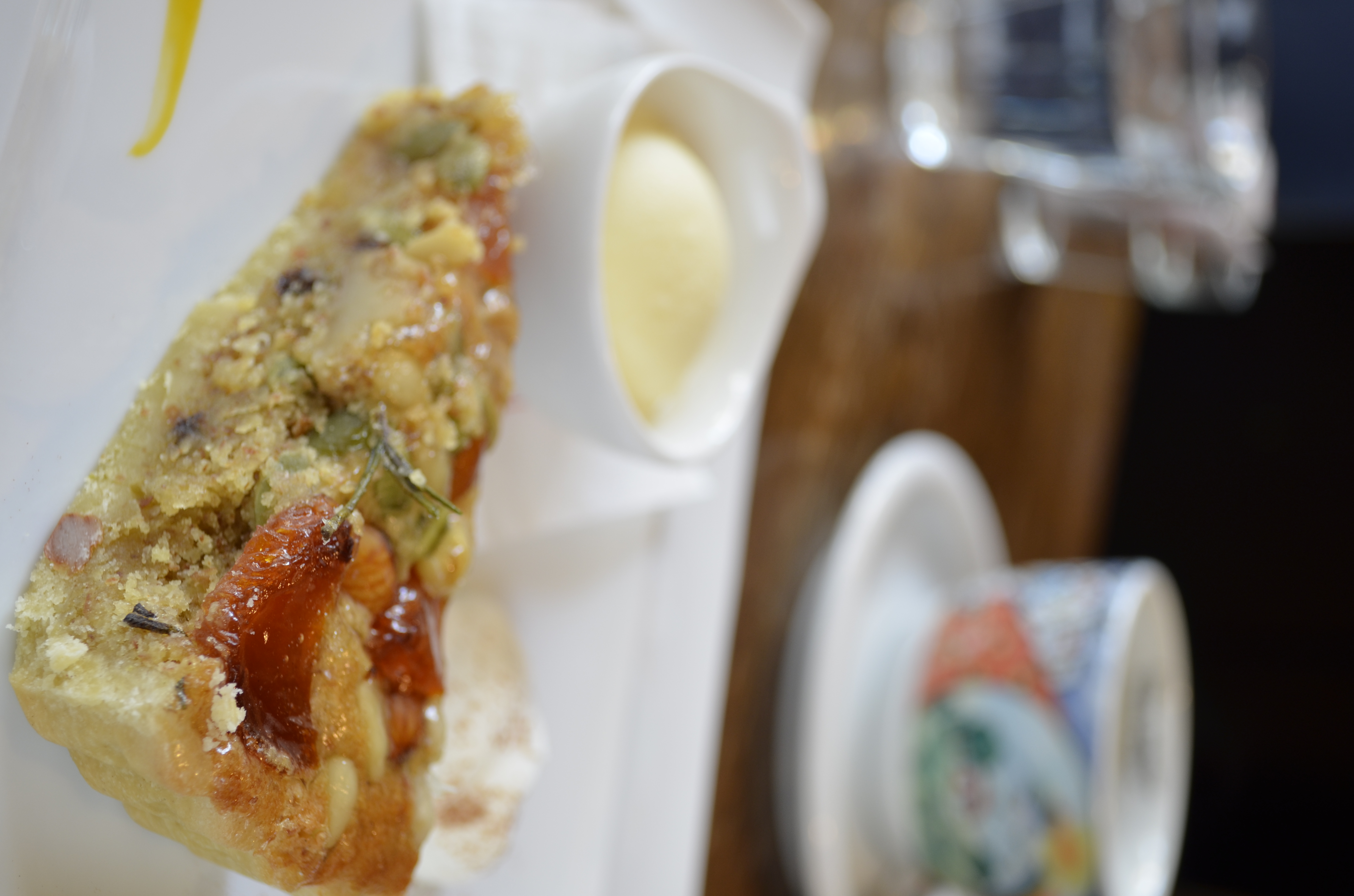 ■絞り優先ＡＥ（F5）/ISO200/WBオート/+1.5EV/焦点距離35mm/ナッツとドライフルーツのタルトタルトの手前の断面にピントが来るようにし、斜め奥にコーヒーカップを配置してタテ位置で撮ることで奥行き感を出しました。