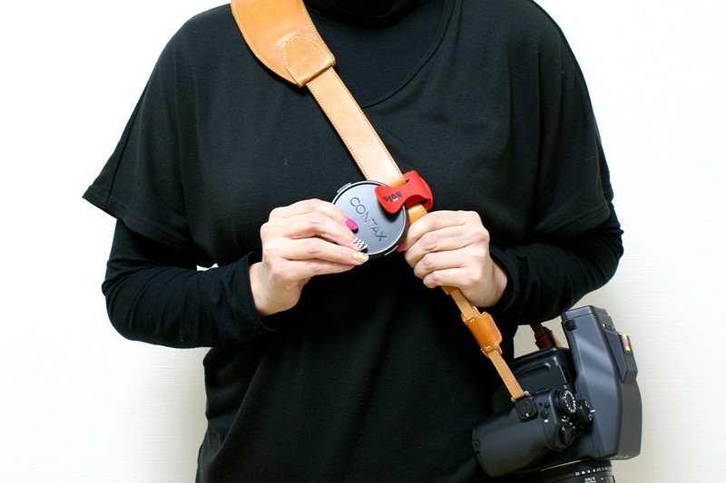 レンズキャップを外したら、レンズキャップホルダーに挟むだけ。カメラを提げた状態で立ったままでも、3秒あればレンズキャップの収納が完了！