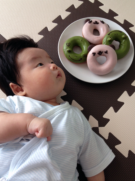 カエルとパンダのドーナツとパチリ。お皿の向こう側からオモチャで気を引いて、視線をドーナツの方に向けました